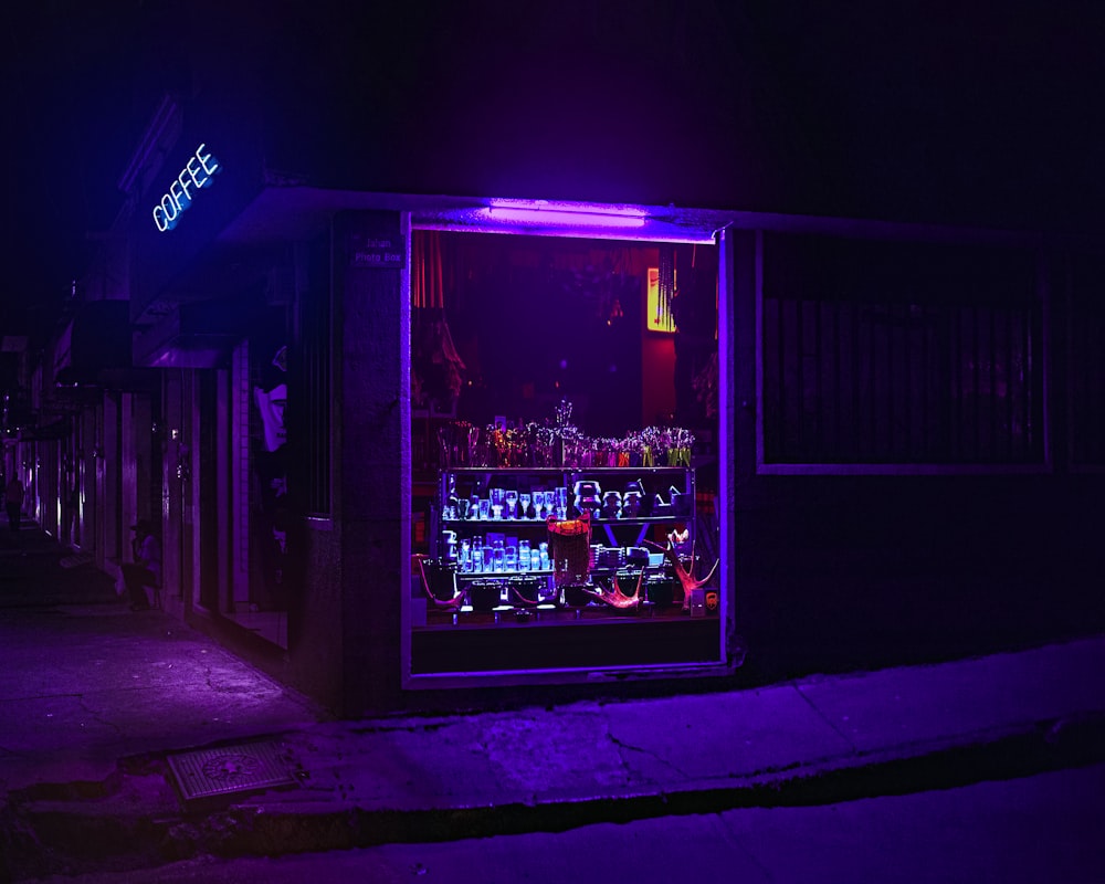 a purple light is shining on a dark street