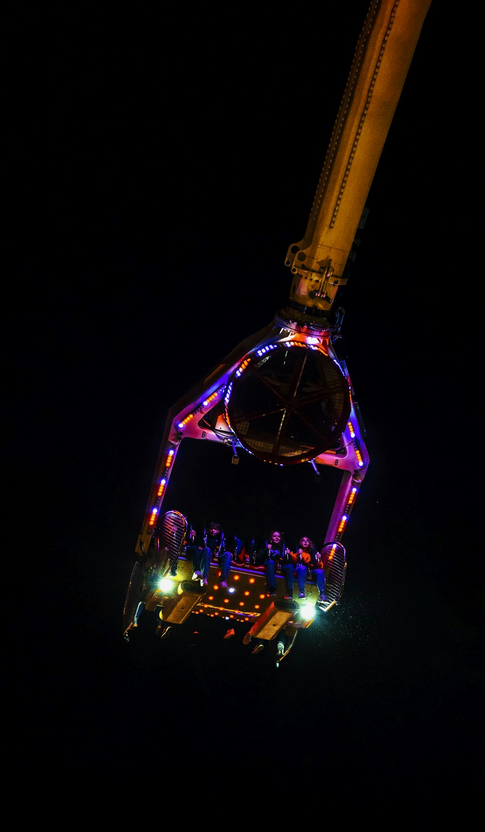 a ferris wheel lit up at night in the dark