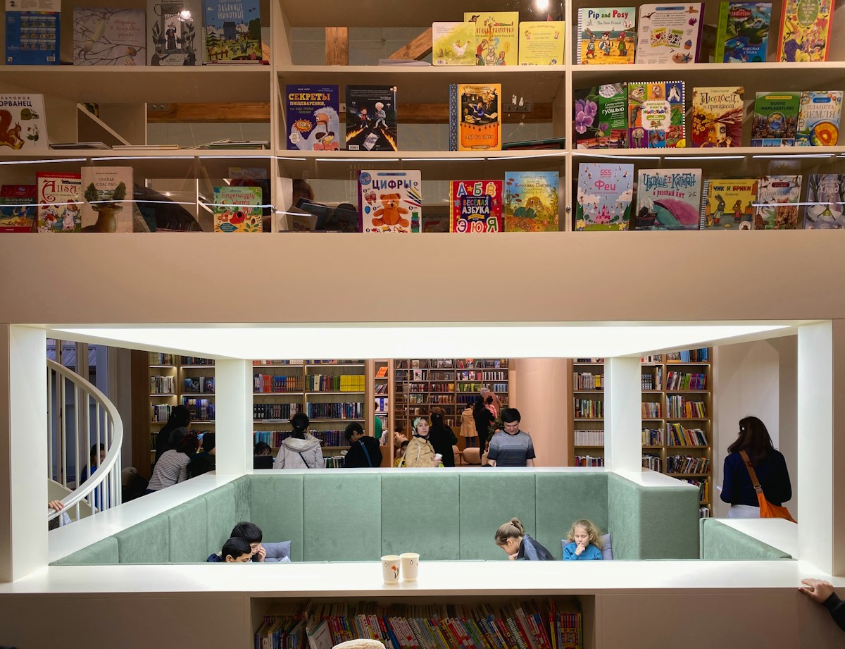 A colorful library with shelves of books and a staircase, ideal for reading activities for children.