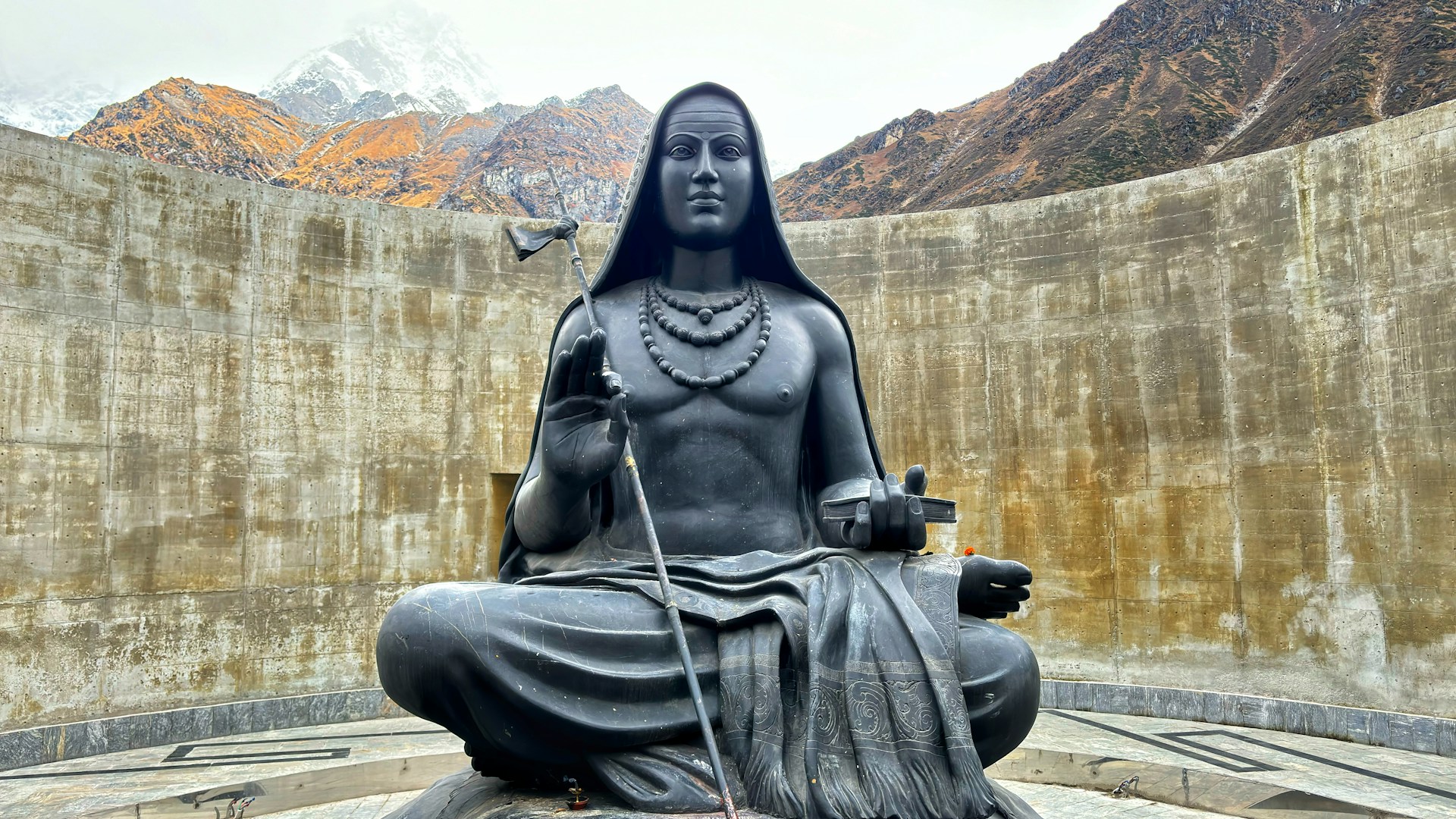 a statue of a woman sitting on top of a rock