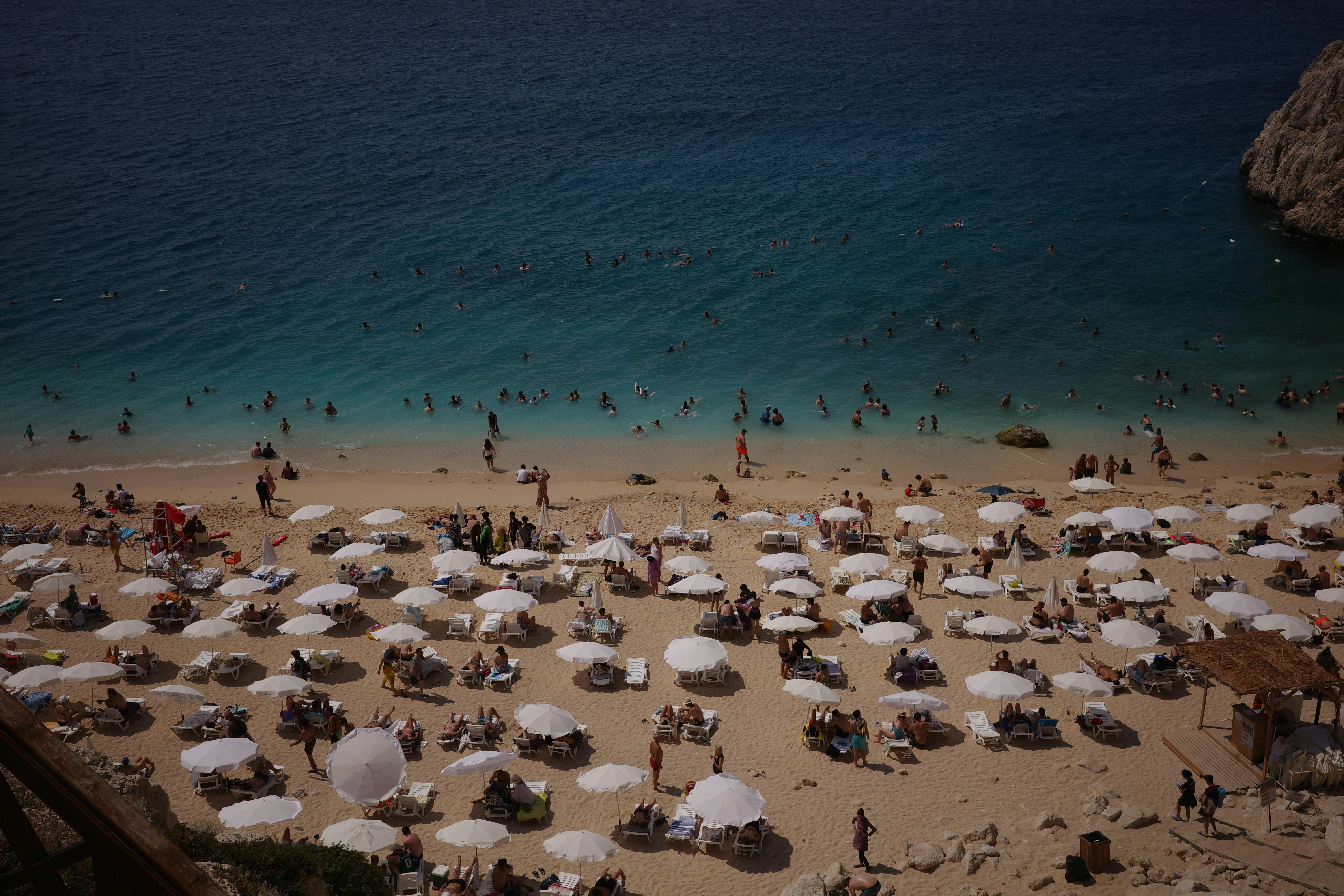 Gran afluencia de bañistas con hamacas y sombrillas en playa de verano