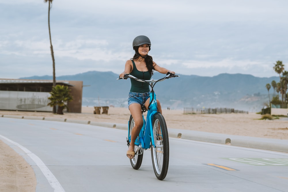 a woman riding a bike down a street