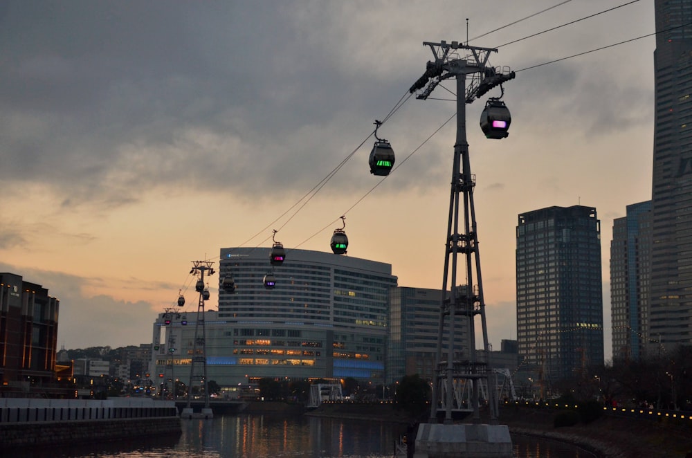 a couple of green lights hanging from a wire over a river