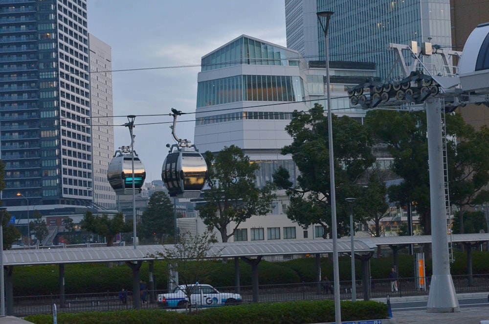 a blue car driving down a street next to tall buildings