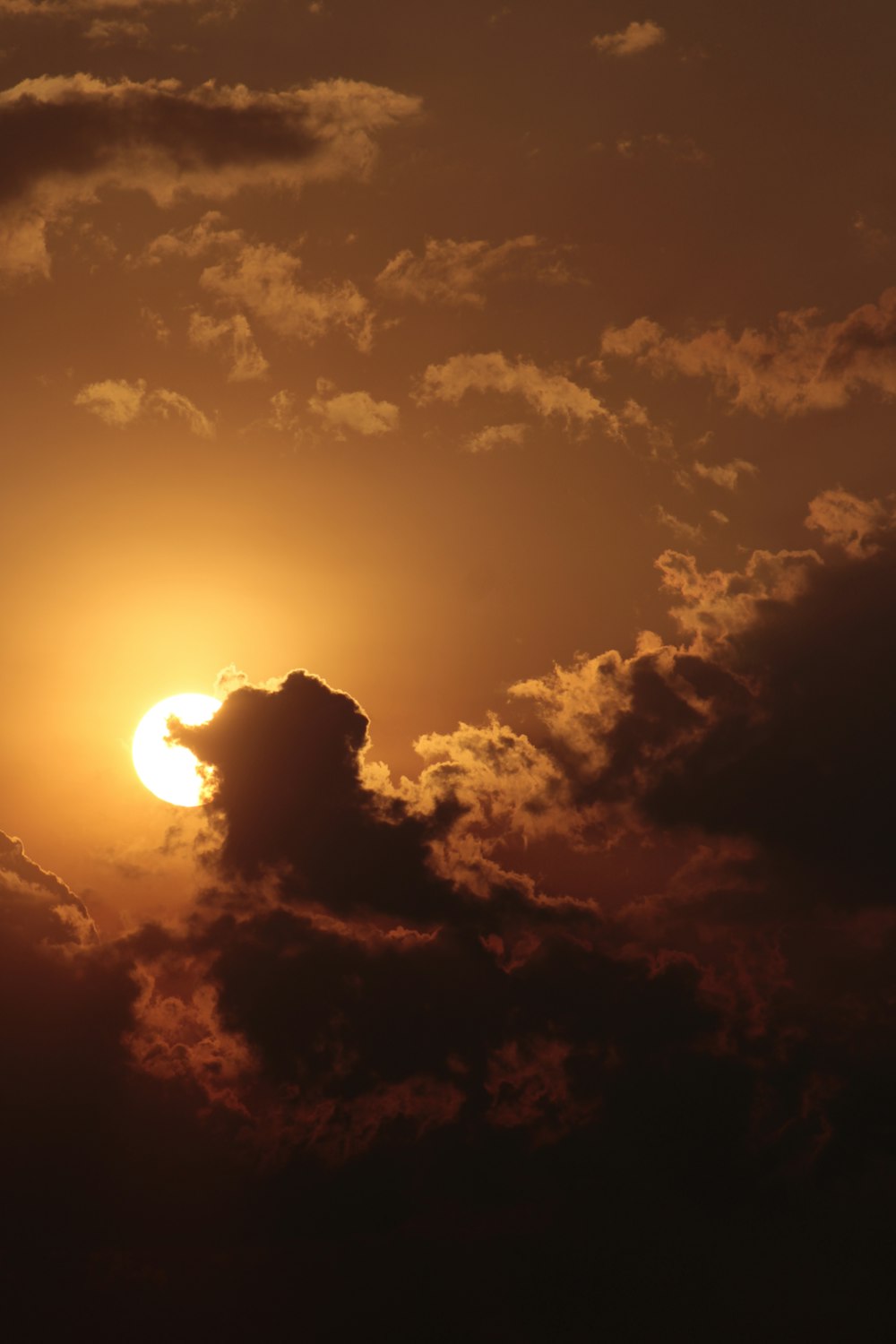 the sun is setting behind a cloud in the sky