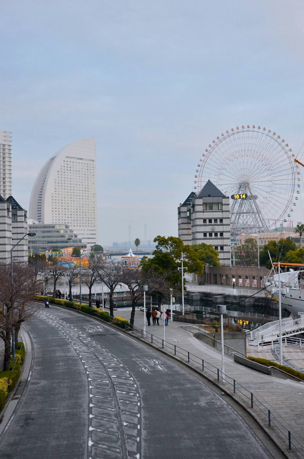 a city street with a ferris wheel in the background