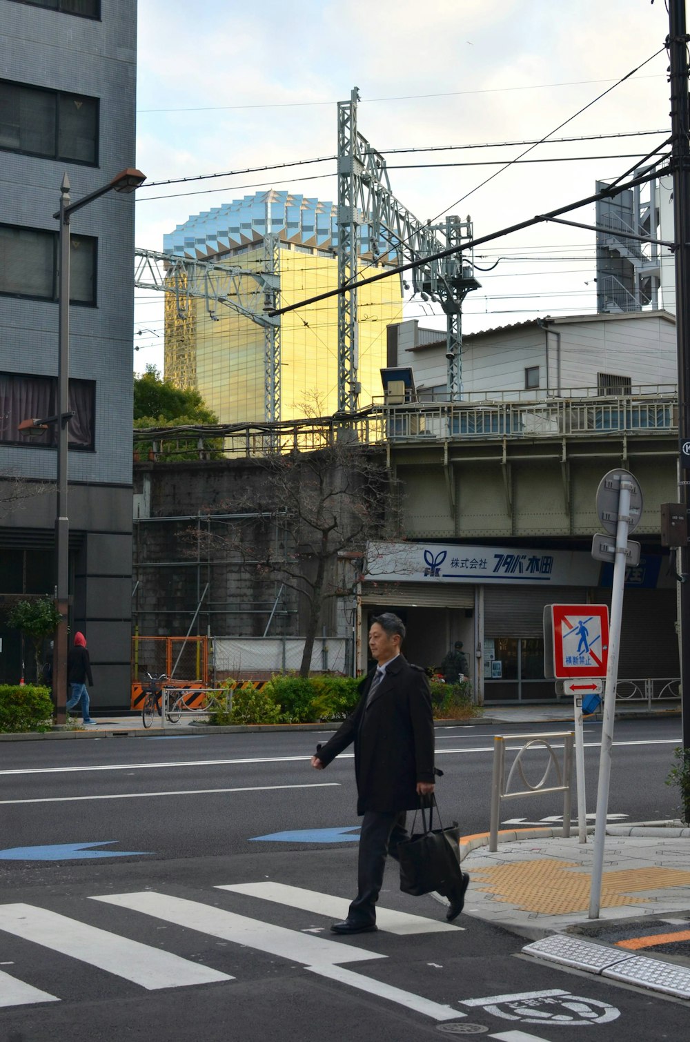 a man walking across a street holding a briefcase