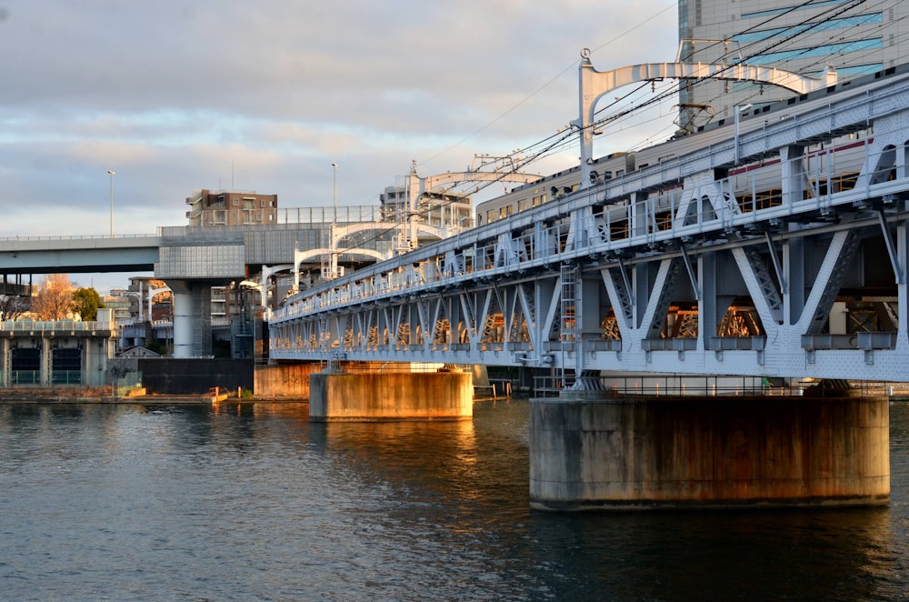 a bridge over a body of water with buildings in the background