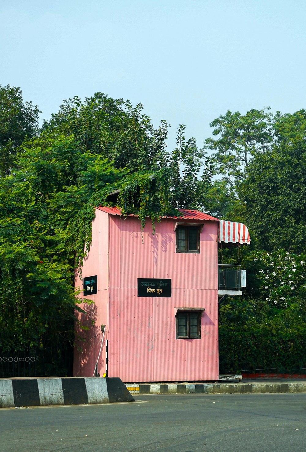 un bâtiment rose surmonté d’un balcon