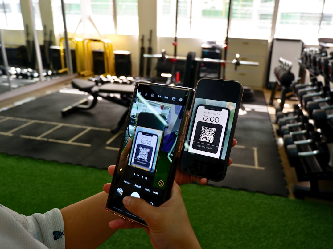 a person holding two cell phones in their hands, A person scanning a QR code from another mobile phone to access a produ