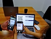 two people sitting at a table using their cell phones