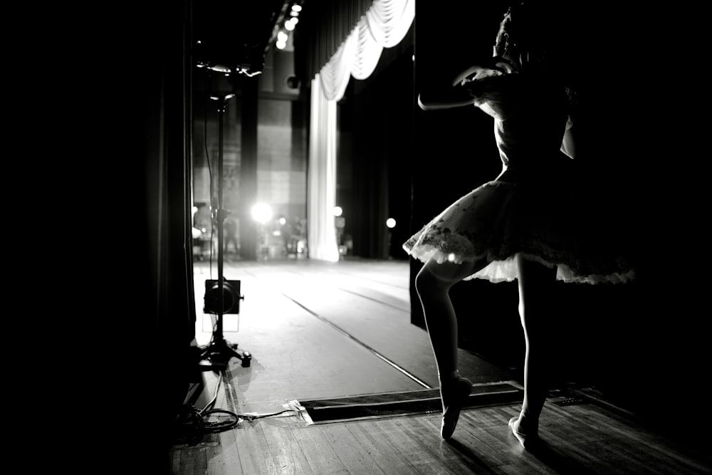 a woman in a tutu dancing on a stage