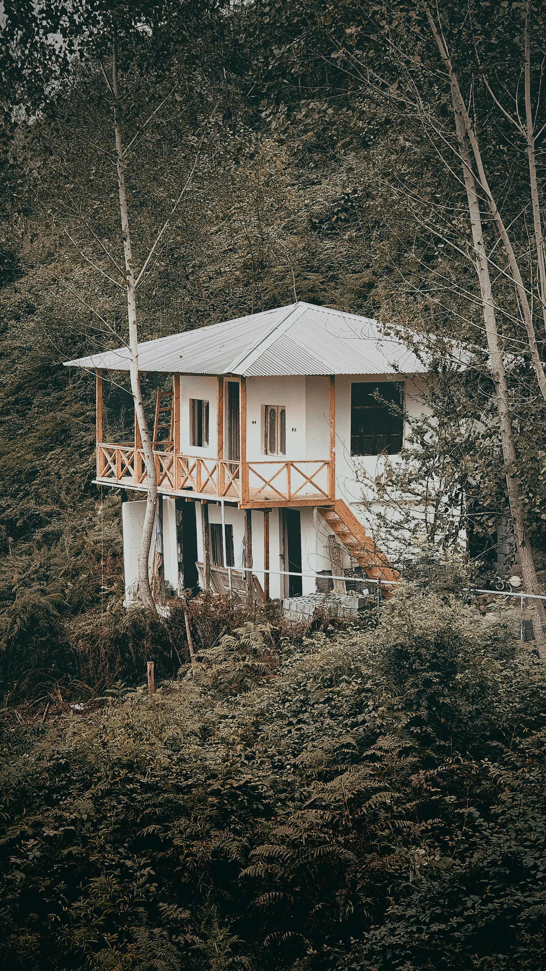 a white house sitting on top of a lush green hillside