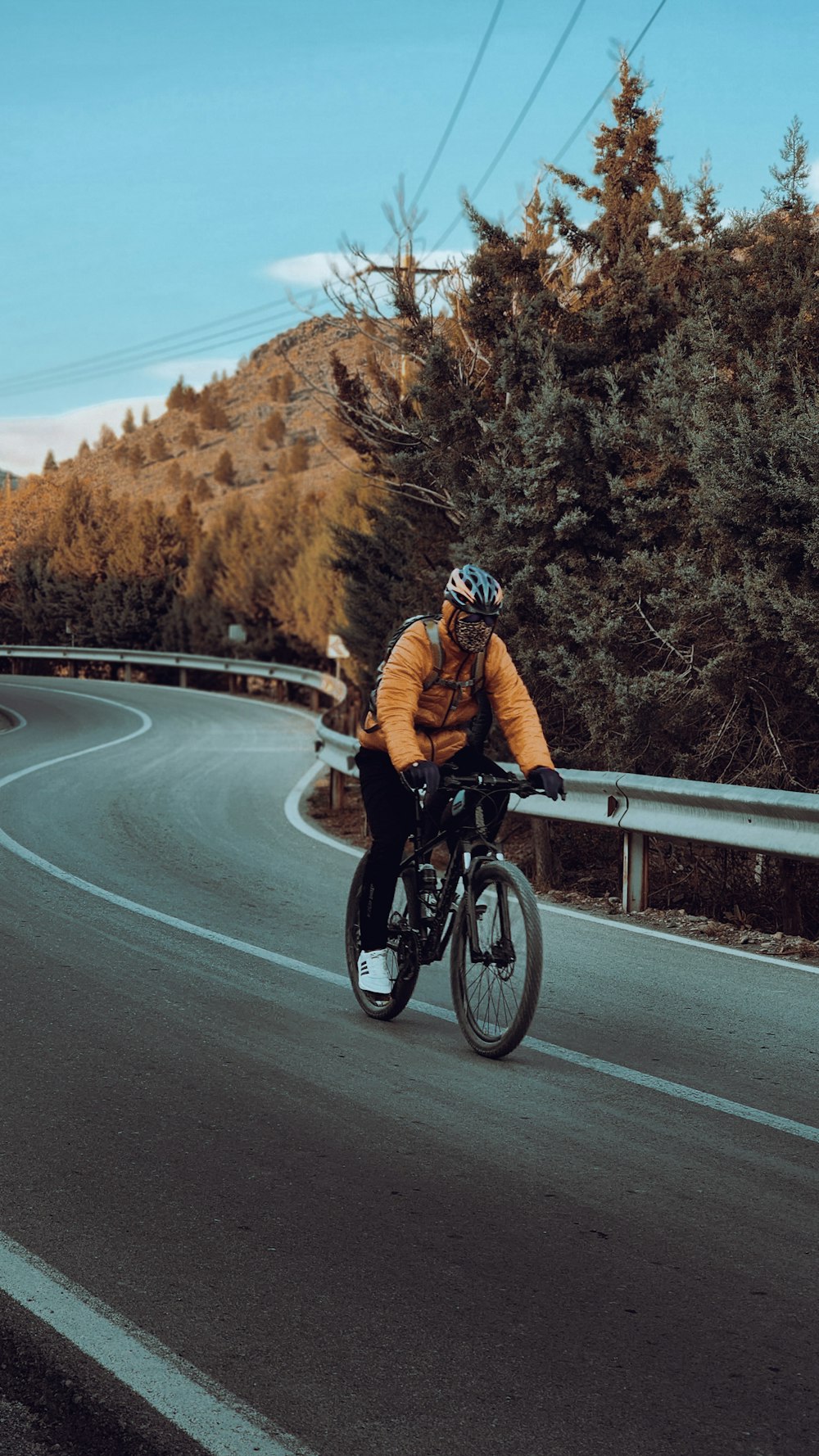 a man riding a bike down a curvy road