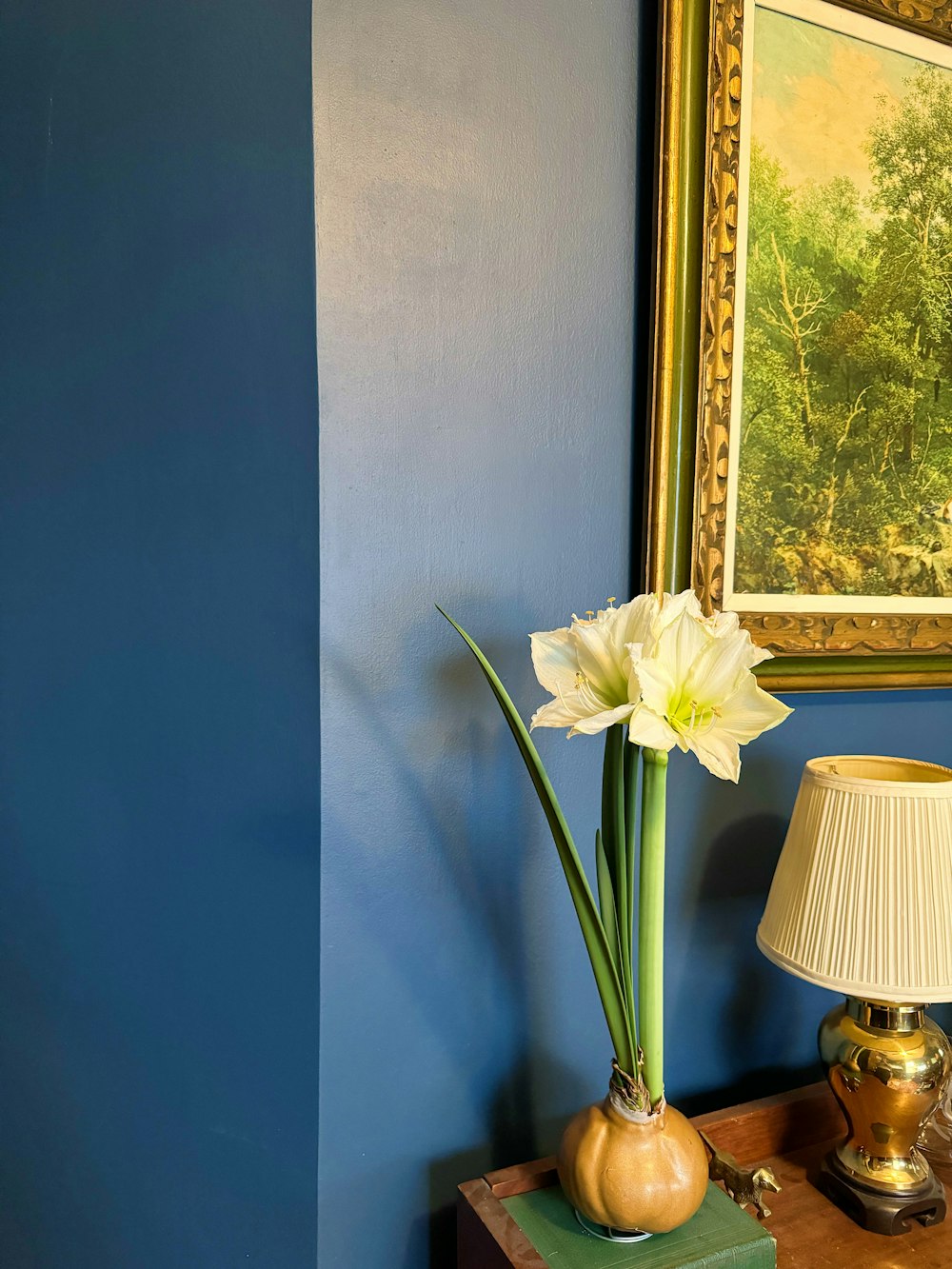 a lamp and a painting on a blue wall