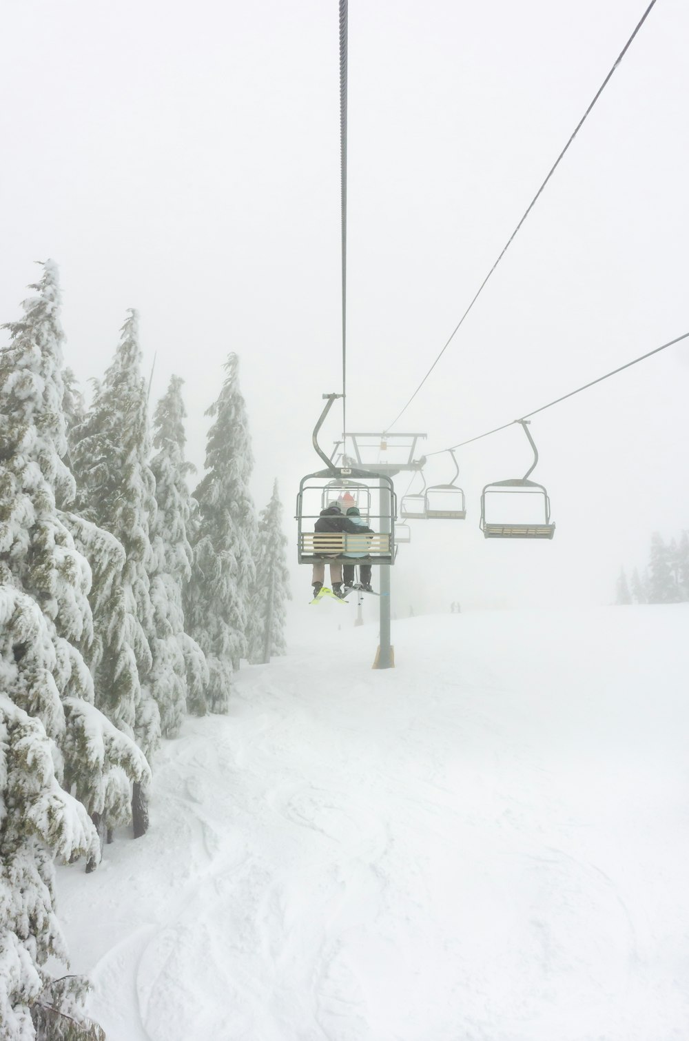 a person riding a ski lift on a snowy day