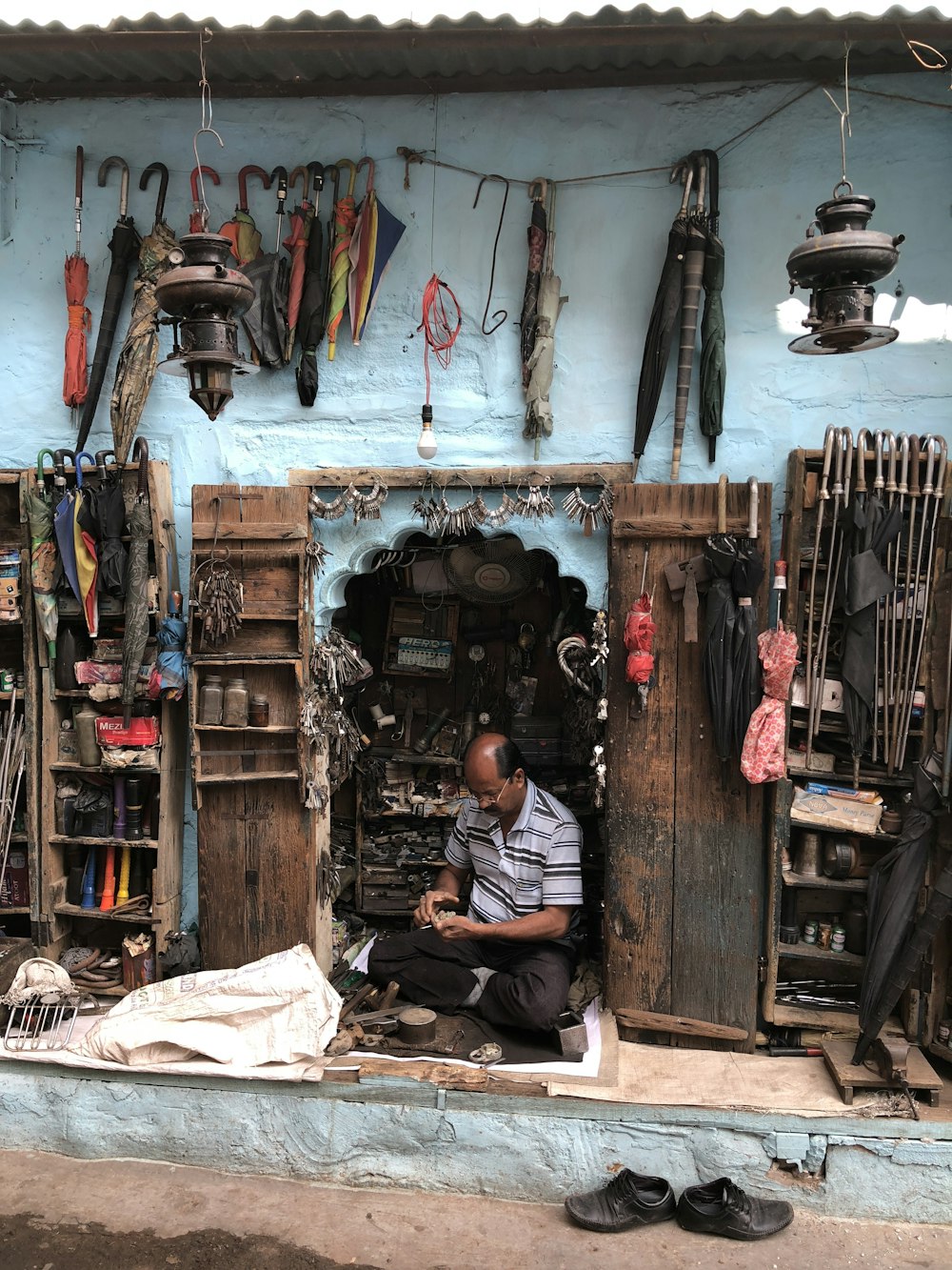 a man sitting in a doorway of a shop