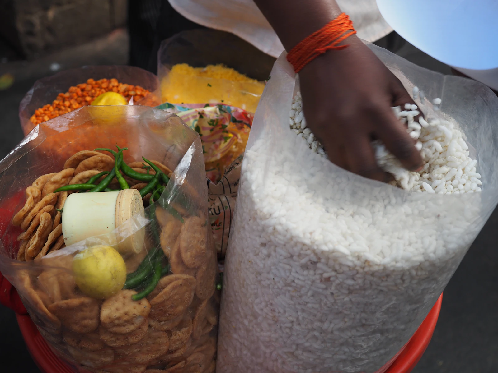 Hands filling a bag with rice from a sack