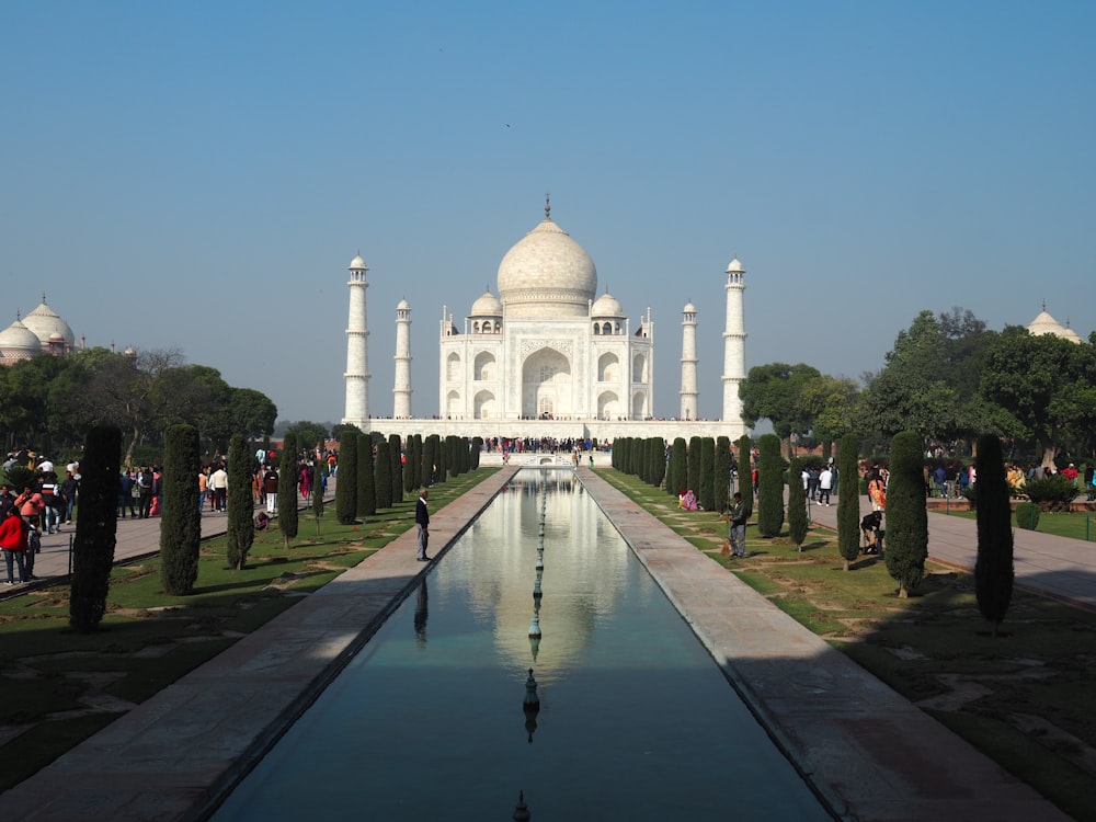 a large white building with a long pool of water in front of it