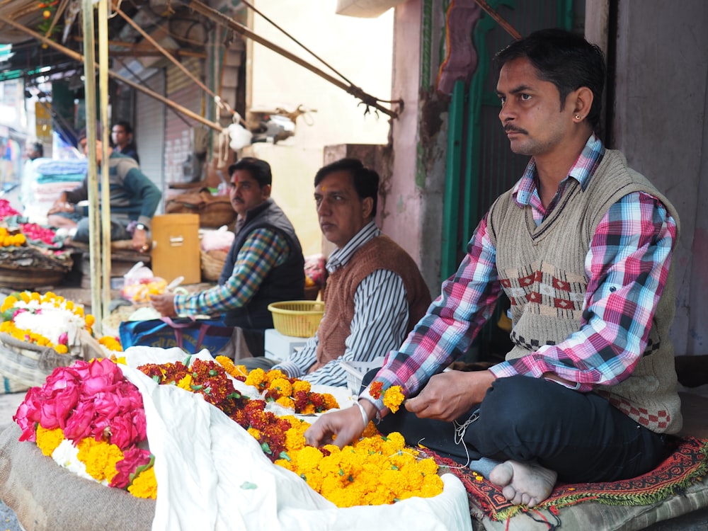 a group of men sitting around a table filled with flowers