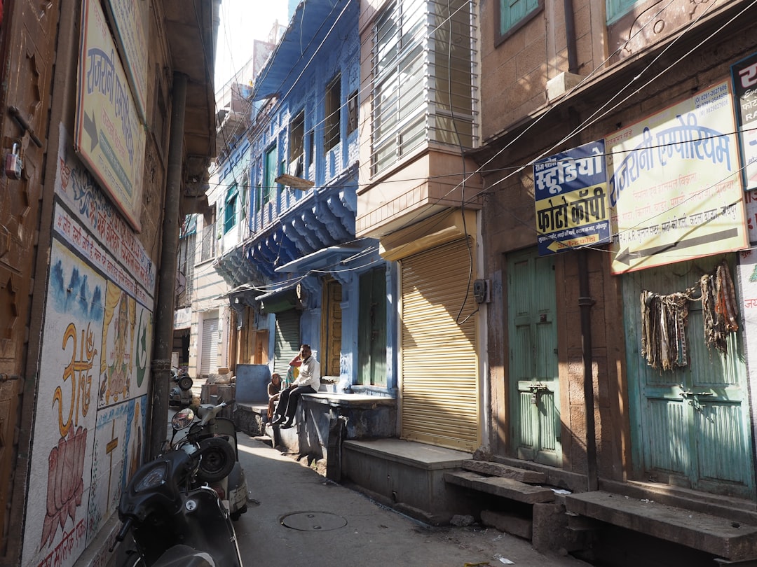 a narrow alleyway with parked motorcycles and colorful buildings, A Street