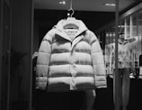 a white puffer jacket hanging in a store window
