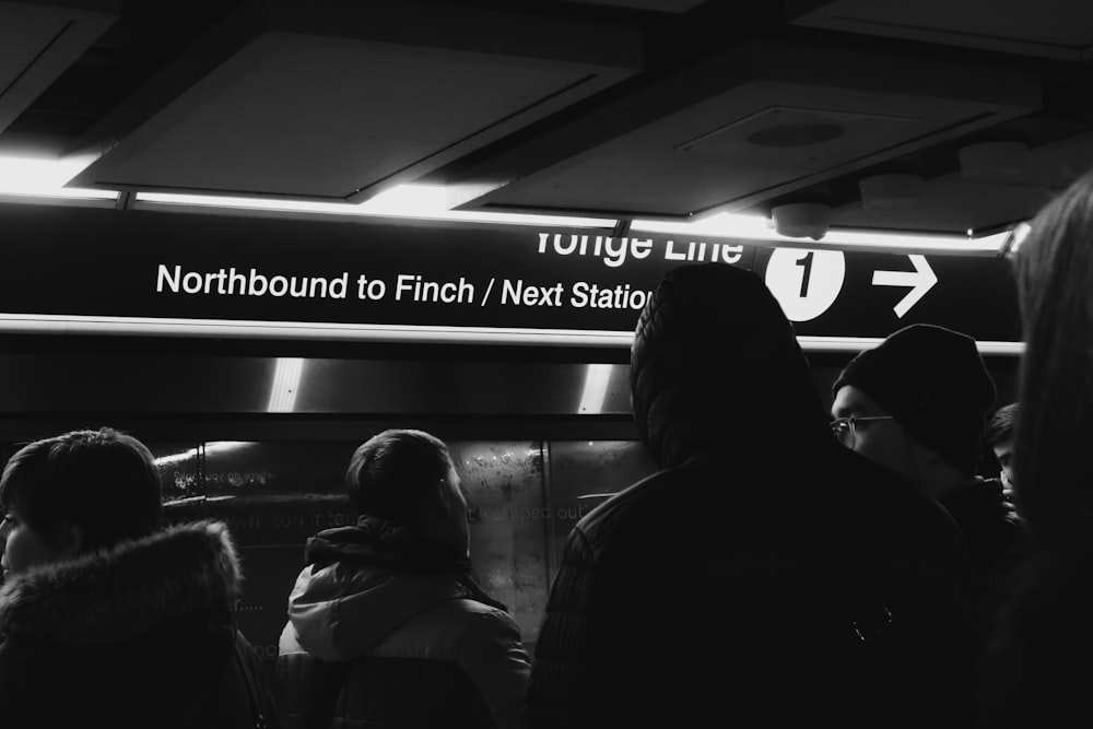 a group of people standing in front of a sign