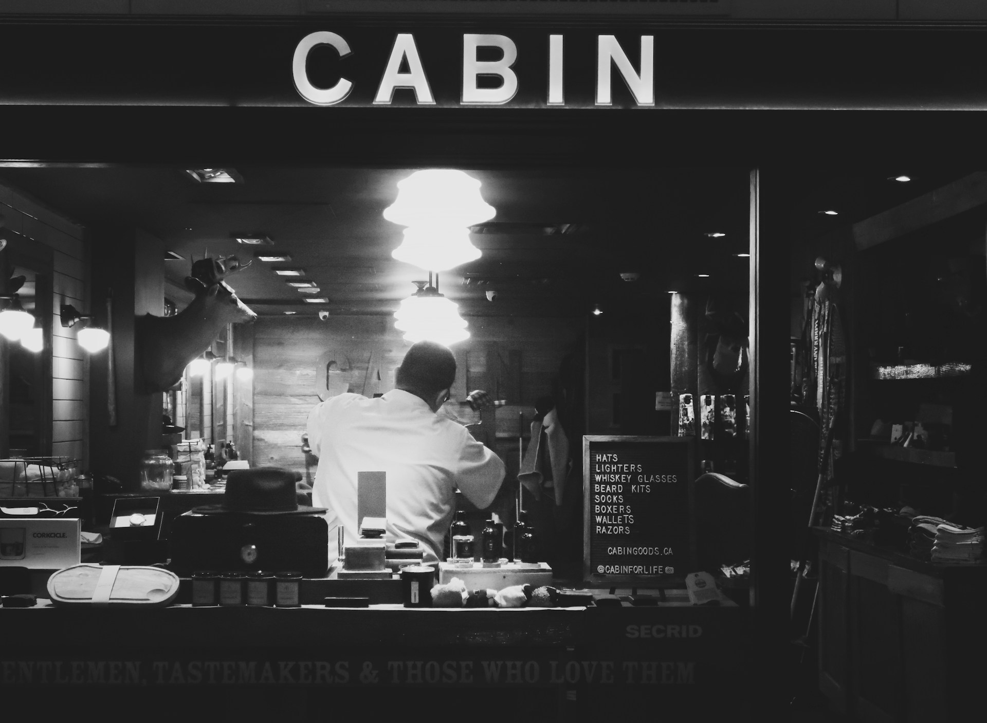 a black and white photo of a man cooking in a restaurant