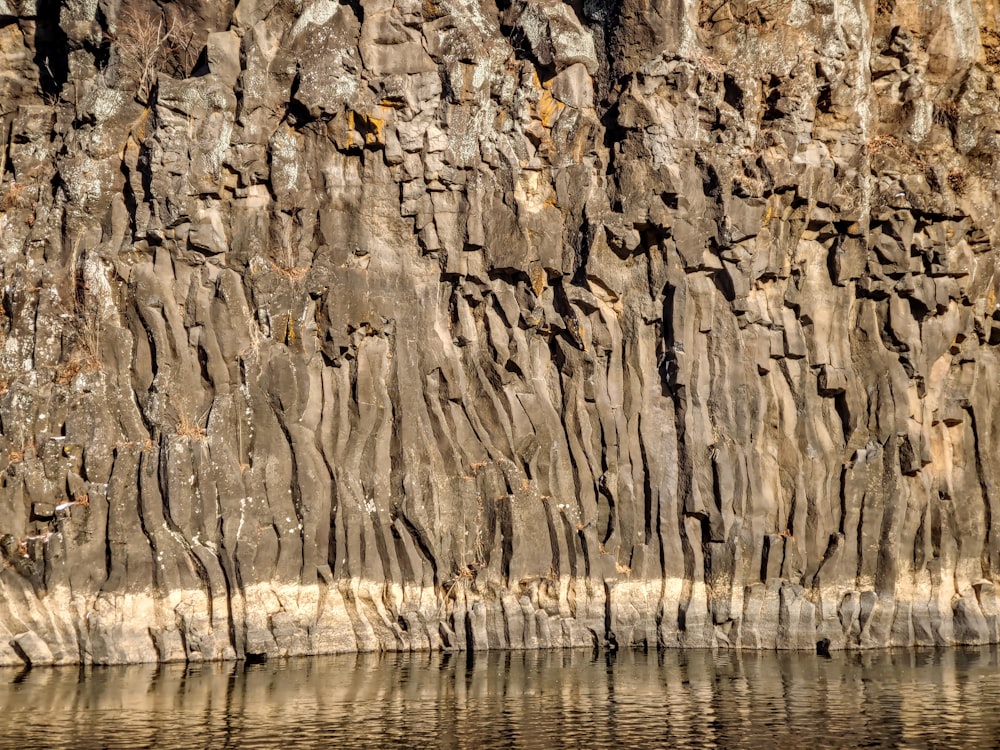 a large rock formation next to a body of water