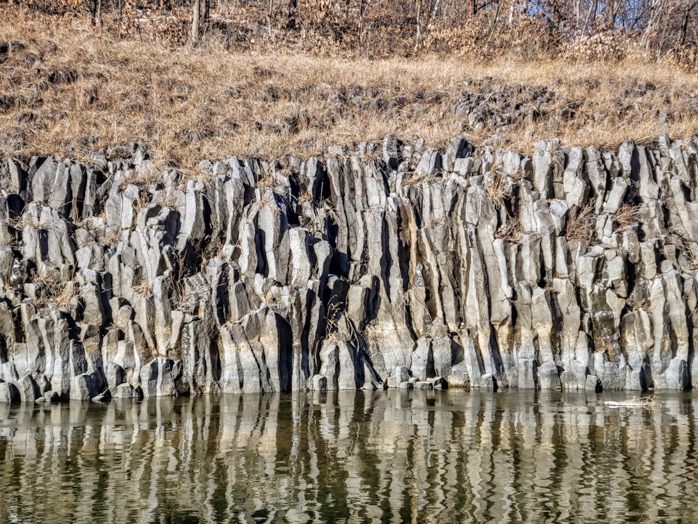 a large rock formation next to a body of water