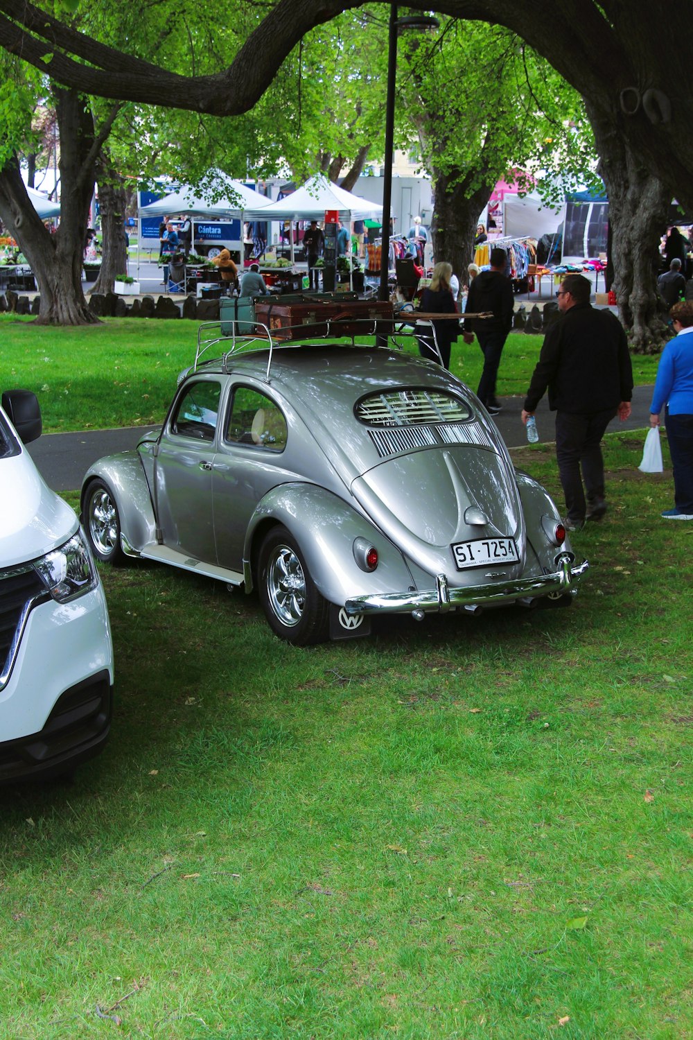 a silver vw beetle parked next to a silver vw bug