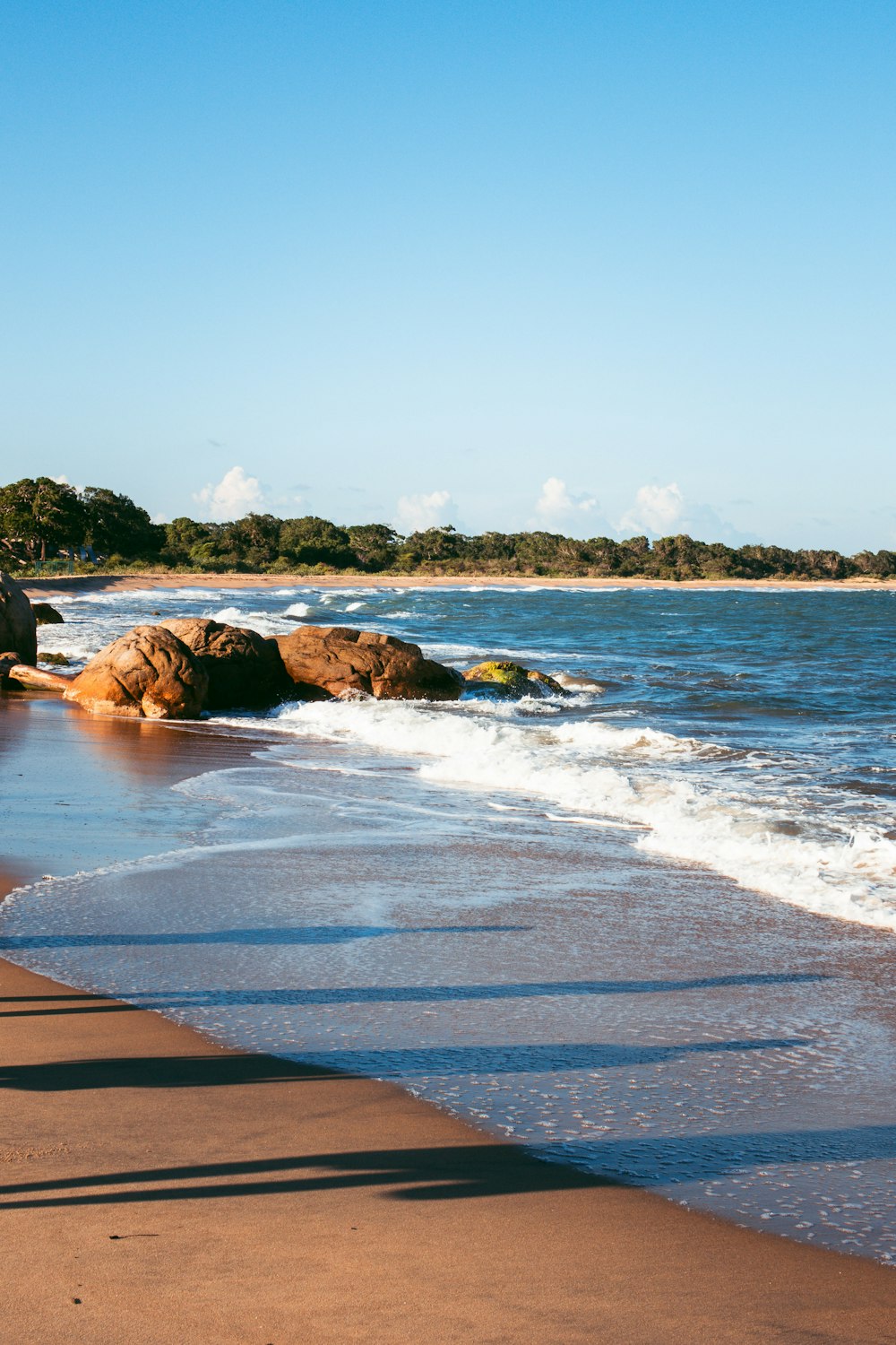 a person walking along a beach next to the ocean