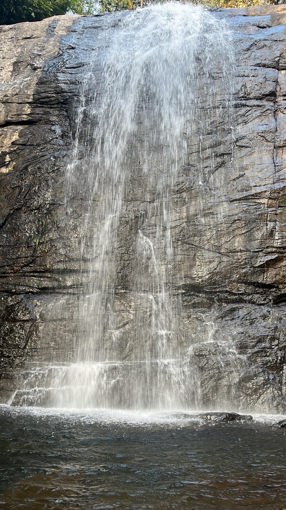 a large waterfall with a man standing under it