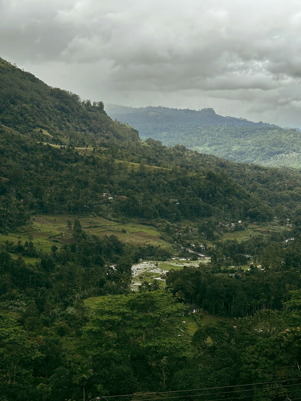 a view of a lush green valley surrounded by mountains