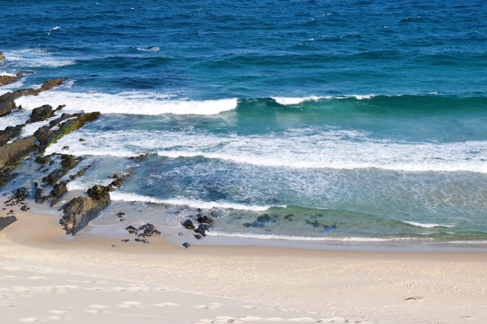 a beach with a wave coming in to the shore