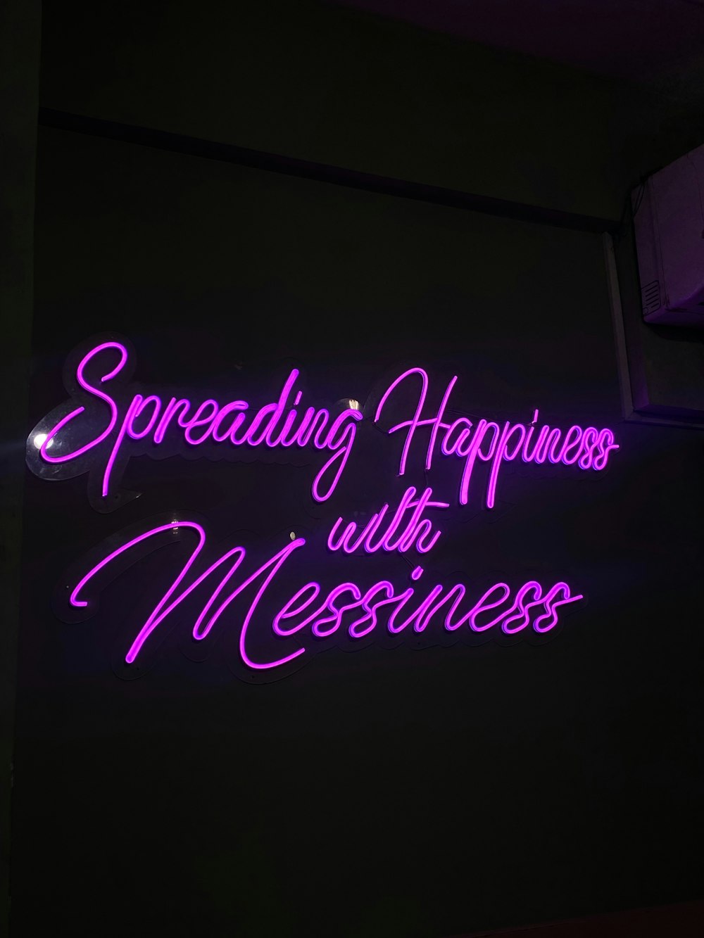 a neon sign that says spreading happiness with messness