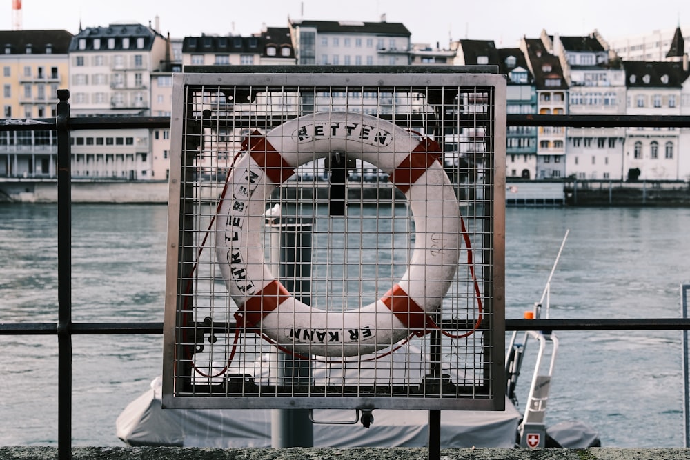 a sign with a life preserver on it near a body of water