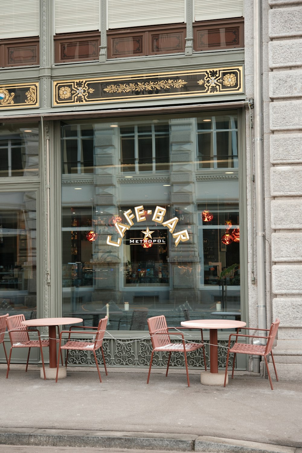 a store front with tables and chairs in front of it