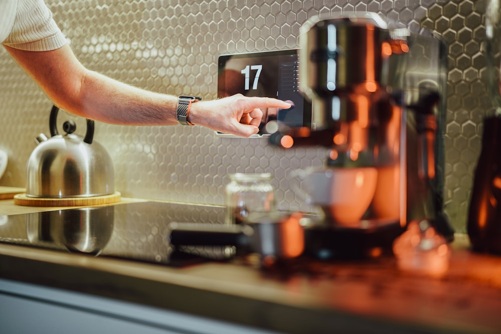 a person pressing a button on a coffee machine