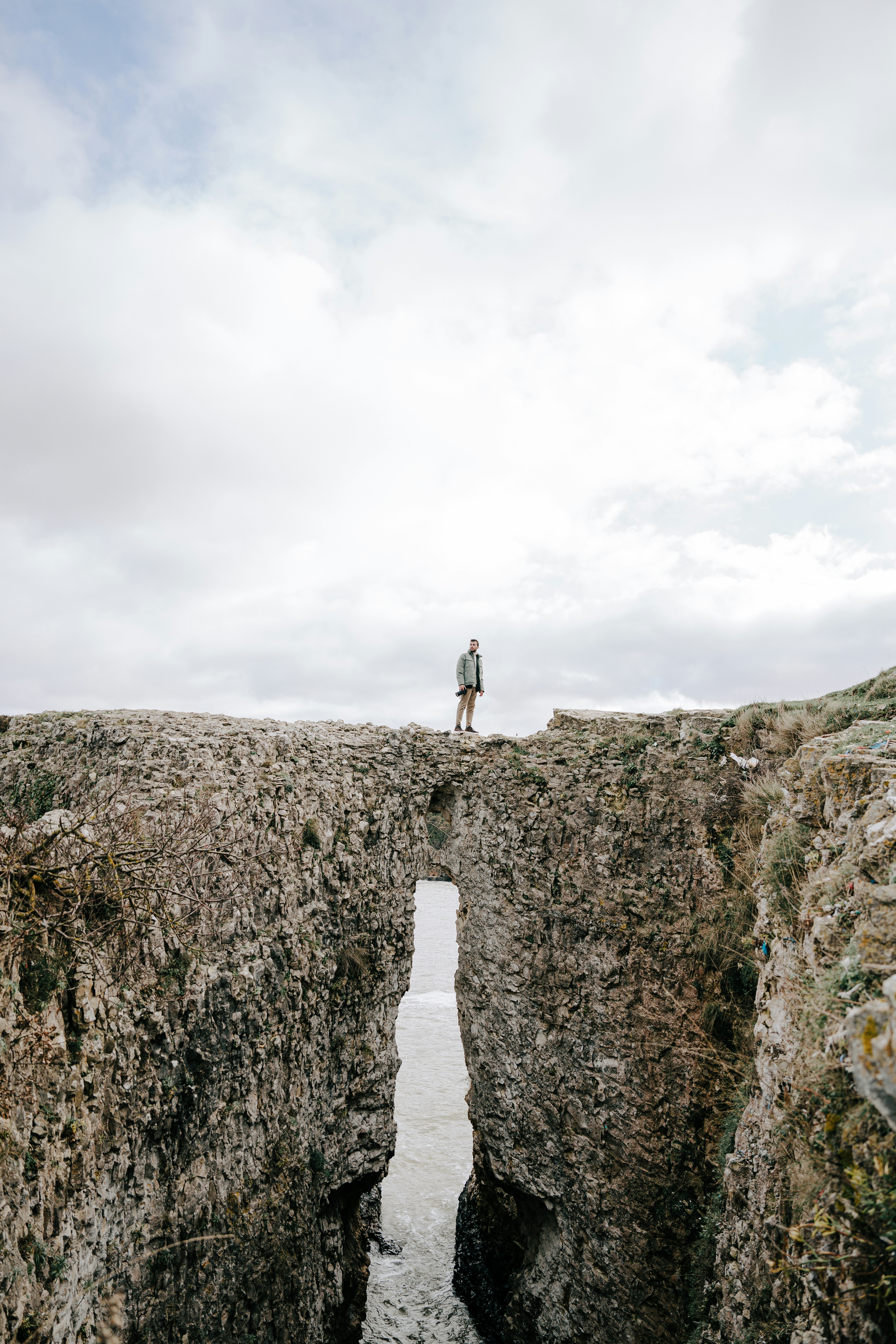 a man standing on the edge of a bridge over a body of water