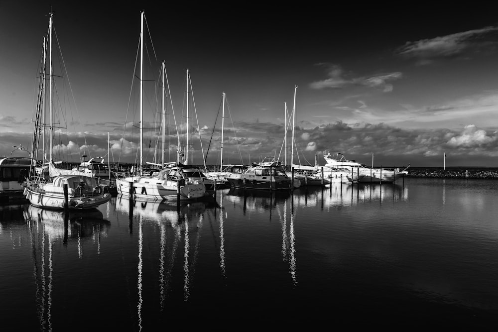 a black and white photo of sailboats in a harbor