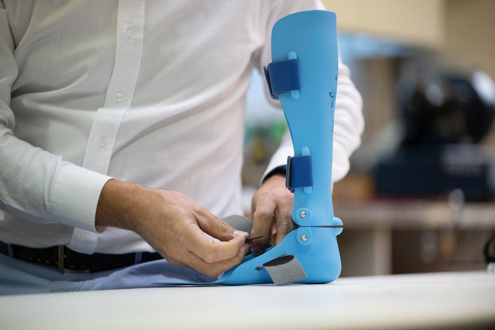 a man is cutting a piece of plastic with a pair of scissors