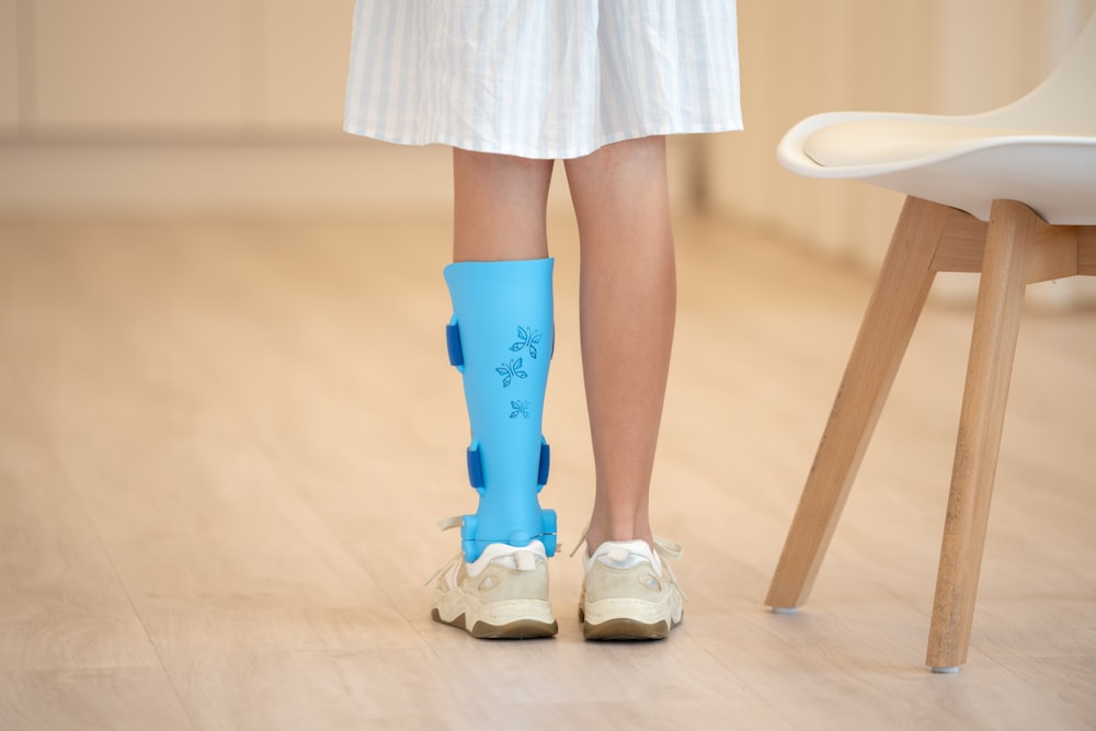 a person with a broken leg wearing a pair of blue boots