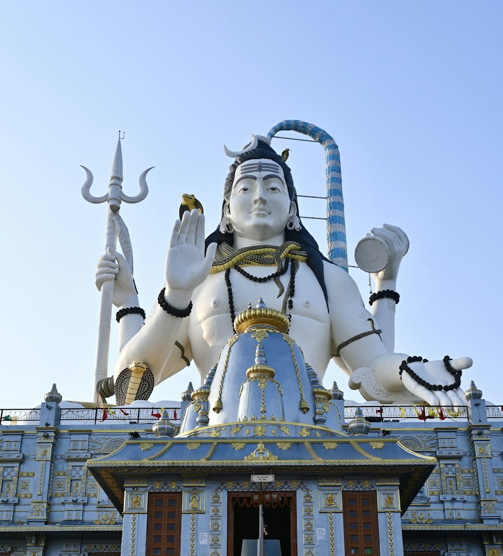 a large statue of a hindu god on top of a building