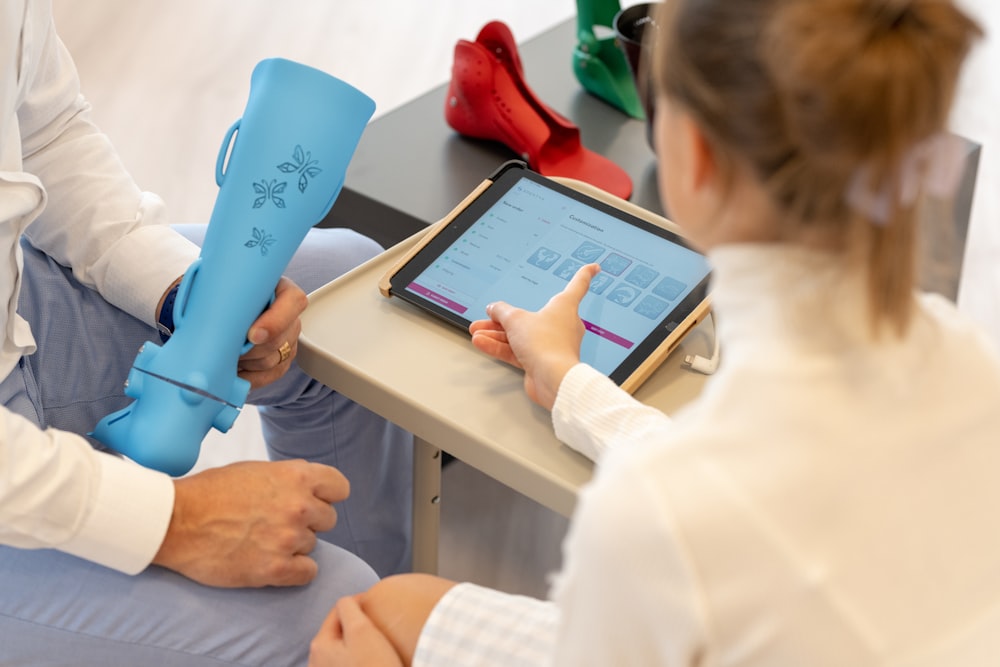 a woman sitting on a table using a tablet