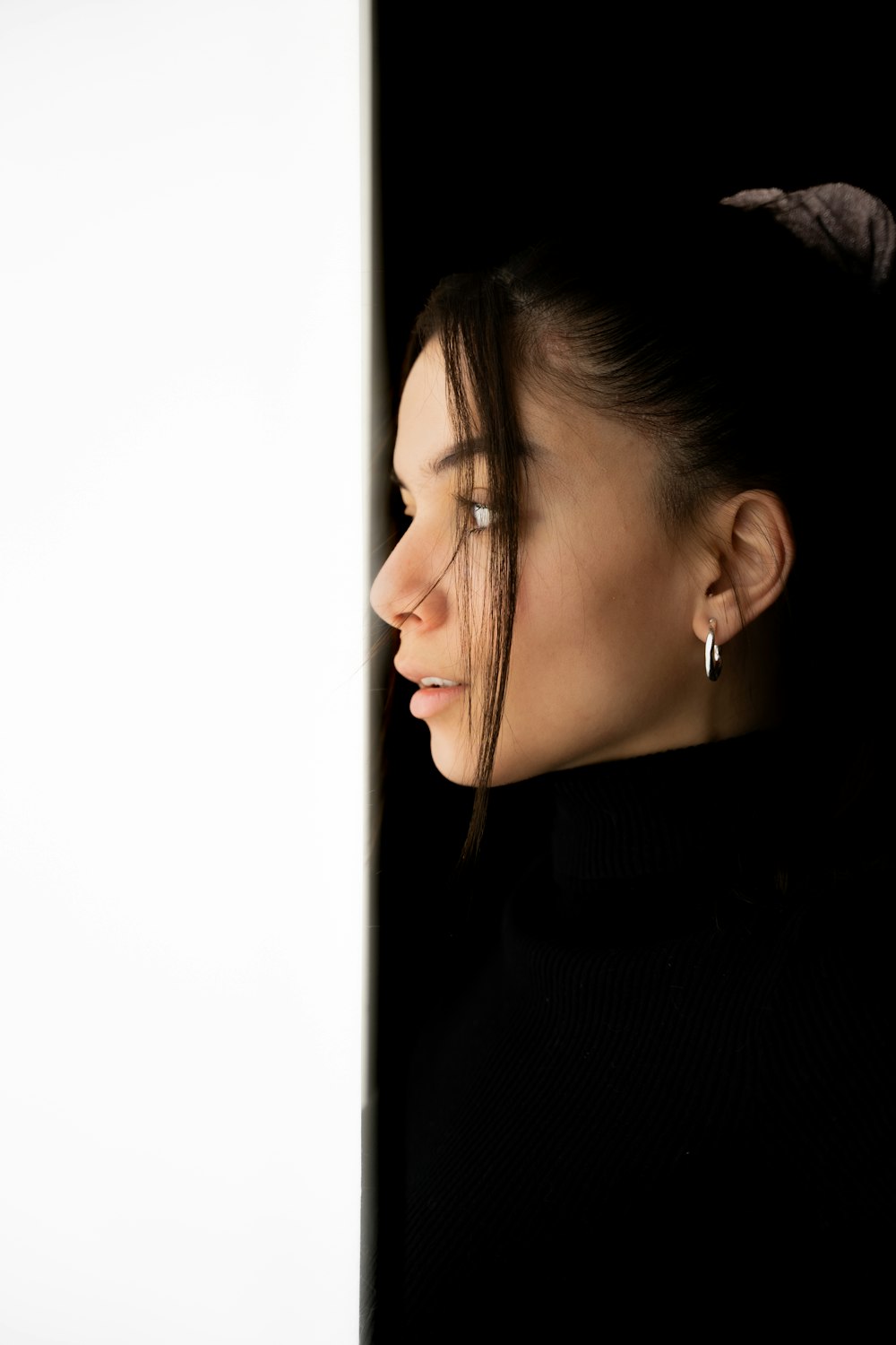 a woman is looking out of a white wall