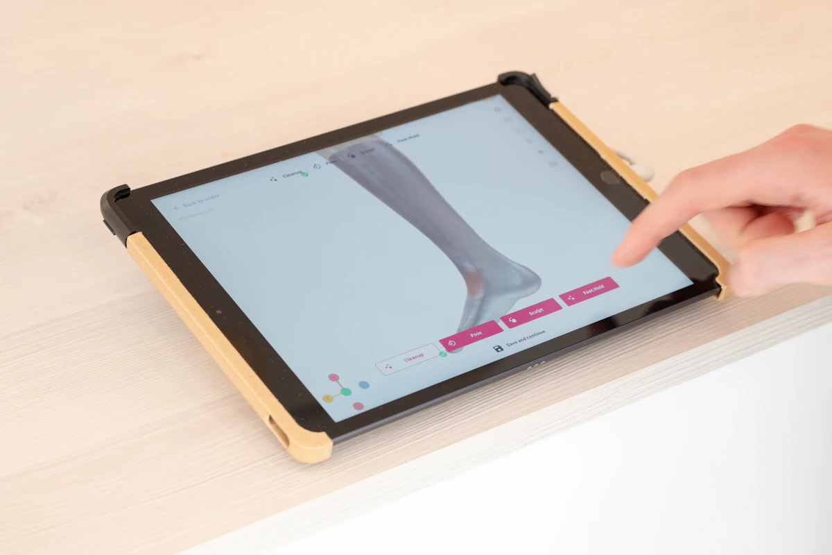 Digitale 3D-scan van een voet en onderbeen op een tablet, gebruikt om de zool op maat te ontwerpen.