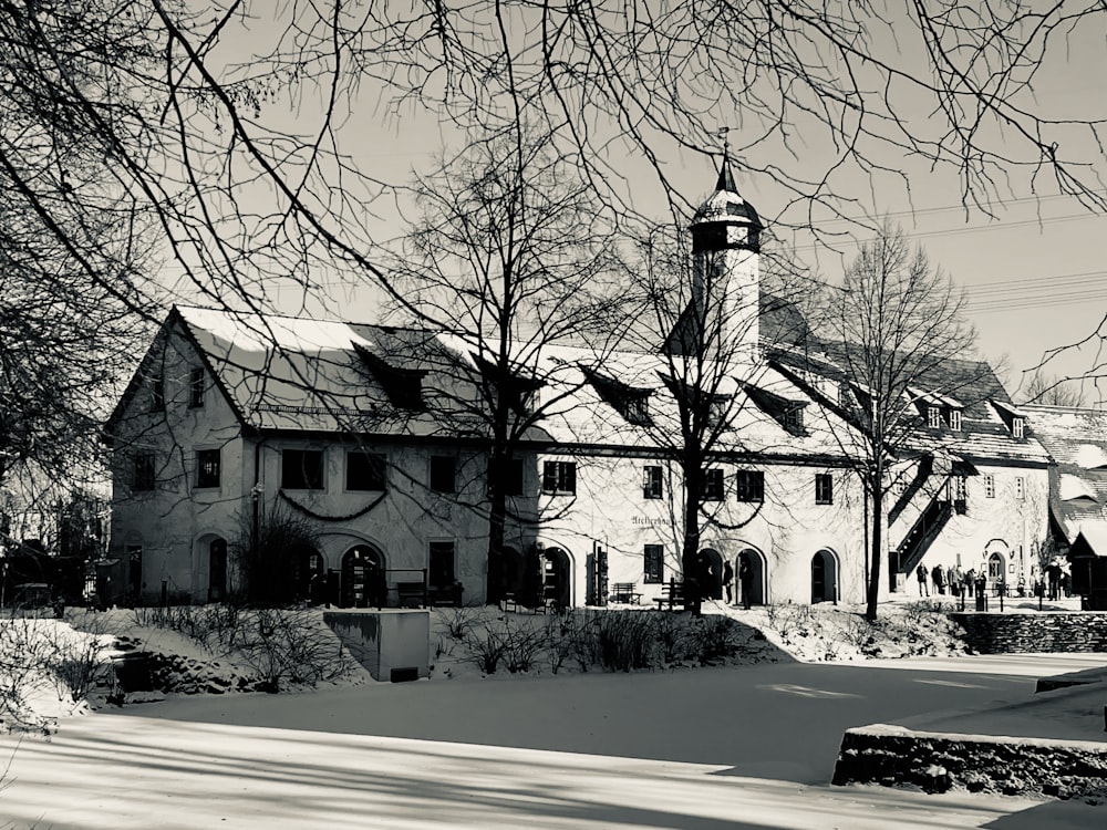 Una foto en blanco y negro de una casa con una torre de reloj