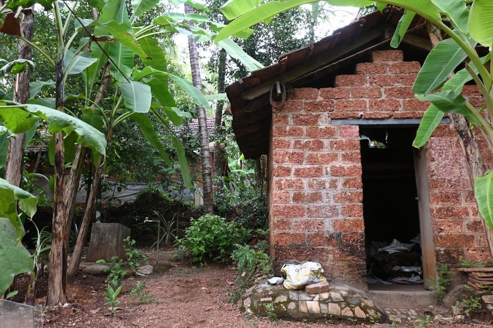 a small brick building surrounded by trees and bushes