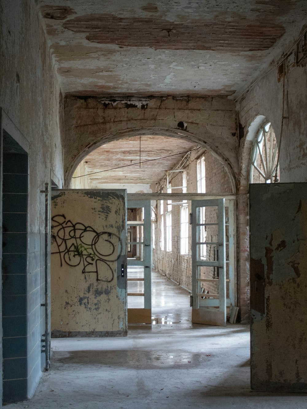 an empty hallway with graffiti on the walls